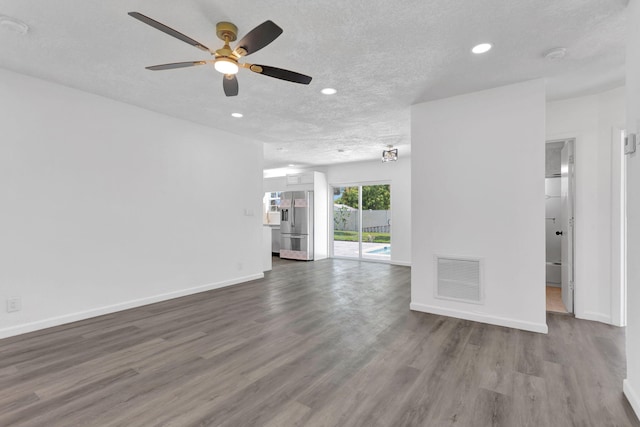 unfurnished living room with recessed lighting, visible vents, a textured ceiling, wood finished floors, and baseboards