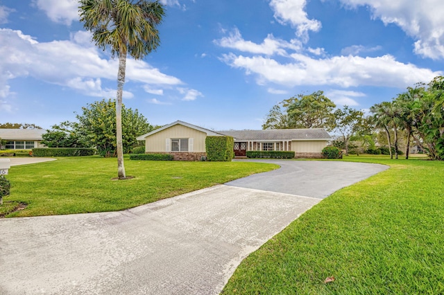 ranch-style home with driveway and a front yard