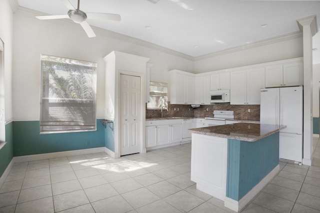 kitchen featuring white appliances, dark countertops, a kitchen island, and white cabinets