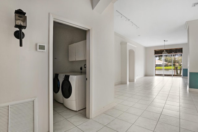 clothes washing area with light tile patterned floors, independent washer and dryer, cabinet space, and visible vents