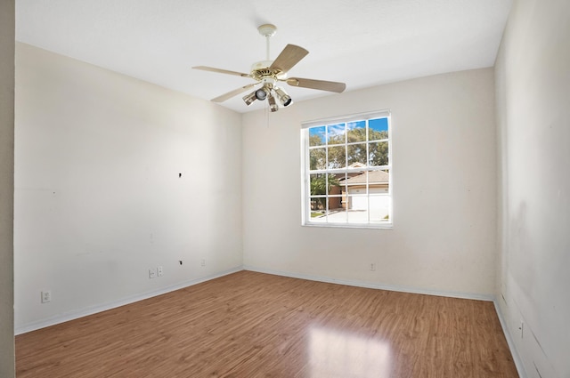 unfurnished room featuring ceiling fan, baseboards, and wood finished floors