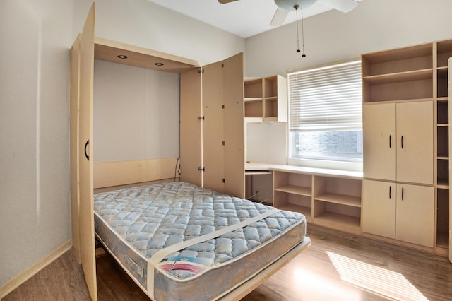 bedroom featuring built in desk and wood finished floors