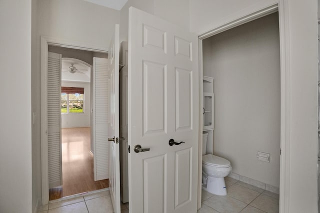 bathroom with a ceiling fan, baseboards, toilet, and tile patterned floors