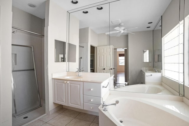 bathroom with a garden tub, two vanities, a sink, a shower stall, and tile patterned flooring