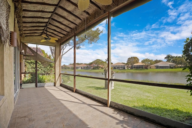 unfurnished sunroom featuring a residential view and a water view