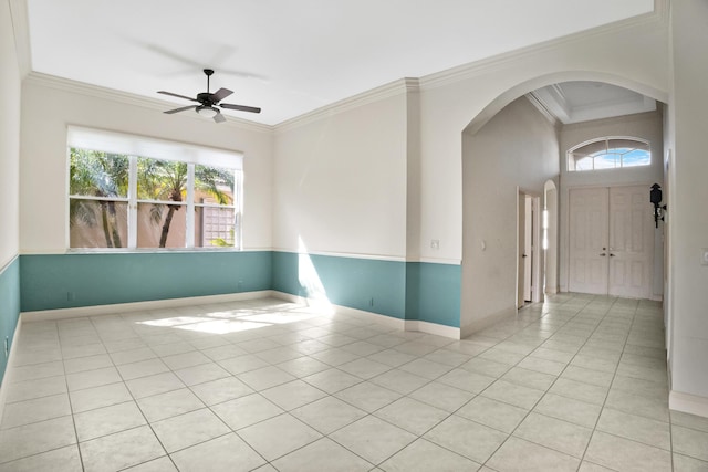 unfurnished room with light tile patterned floors, a healthy amount of sunlight, and crown molding