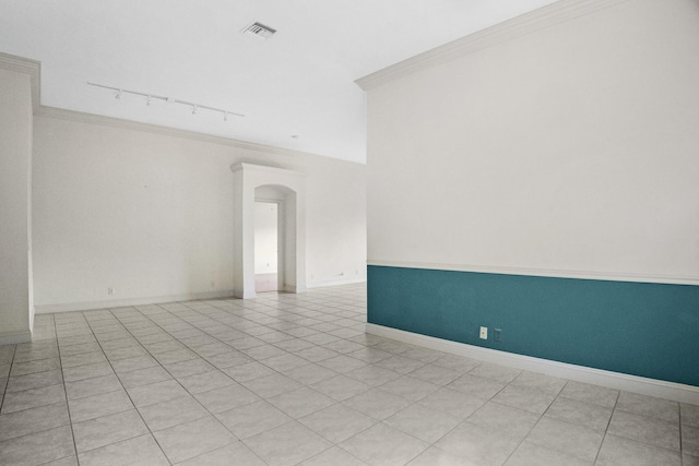 unfurnished room featuring ornamental molding, arched walkways, visible vents, and baseboards