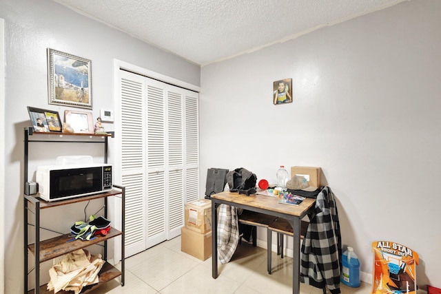 home office with a textured ceiling and light tile patterned floors