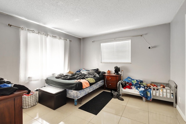 bedroom featuring light tile patterned floors and a textured ceiling