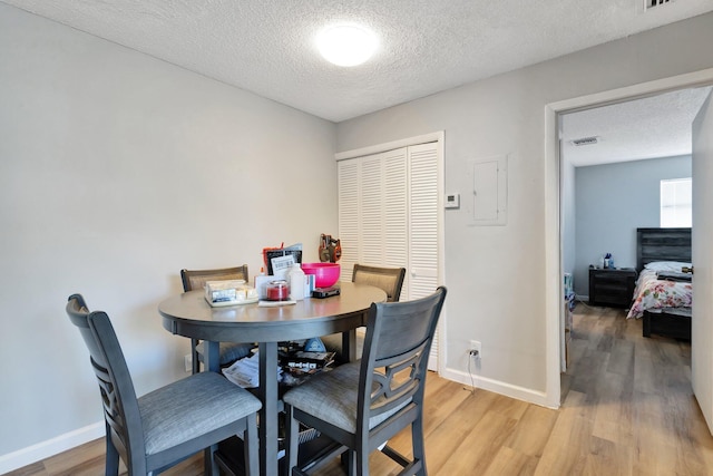 dining room featuring wood finished floors, visible vents, and baseboards