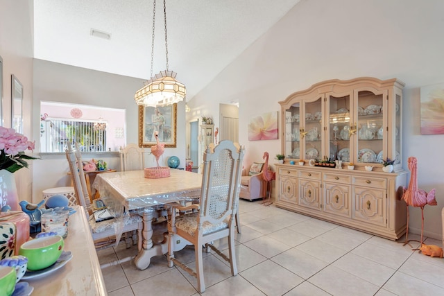 dining space with high vaulted ceiling, visible vents, and light tile patterned floors