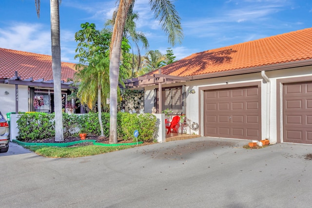 view of front of home featuring a garage, a tile roof, and stucco siding