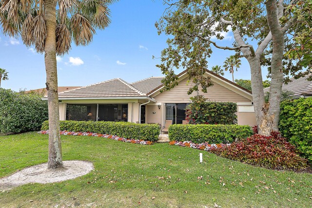 single story home with a front yard and a tile roof