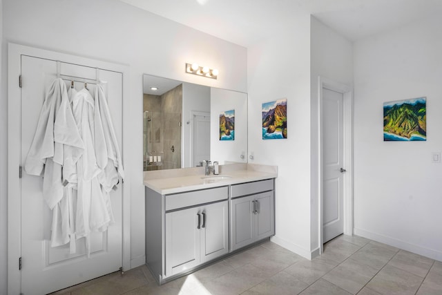 bathroom with tile patterned floors, a shower stall, baseboards, and vanity