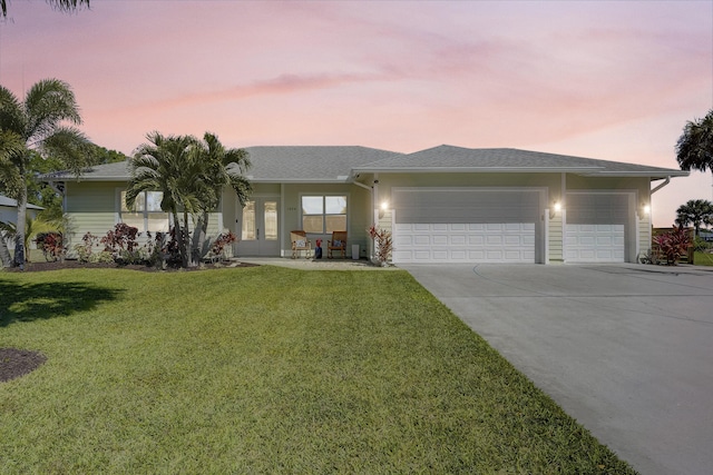 single story home featuring a front yard, french doors, an attached garage, and concrete driveway