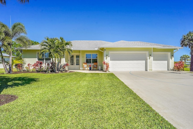 ranch-style house with a garage, a front yard, french doors, and driveway