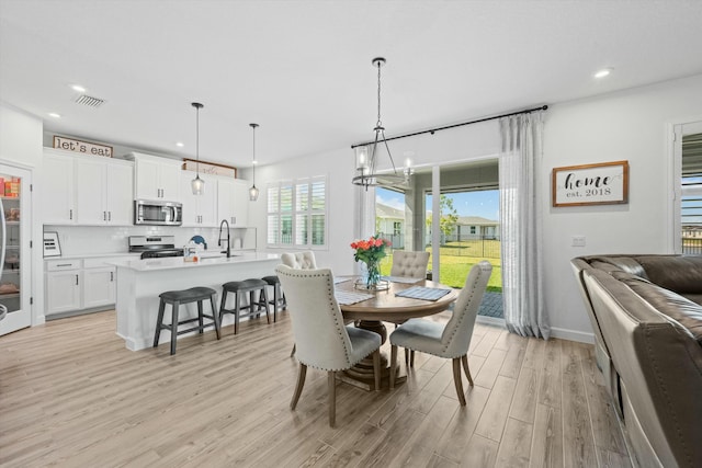 dining space featuring recessed lighting, visible vents, a notable chandelier, and light wood finished floors