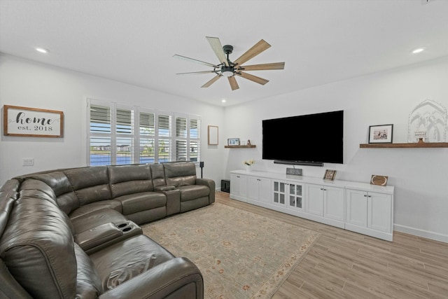 living area featuring baseboards, light wood-type flooring, a ceiling fan, and recessed lighting