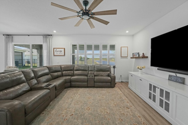 living area featuring a ceiling fan, recessed lighting, baseboards, and light wood finished floors