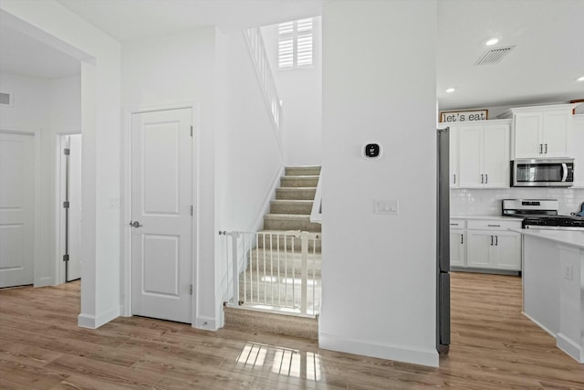 staircase with recessed lighting, visible vents, baseboards, and wood finished floors