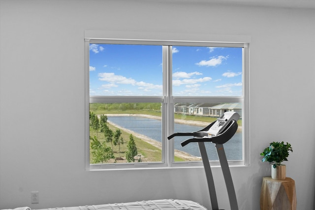 bedroom with multiple windows and a water view