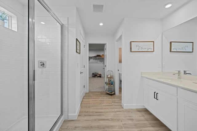 full bath with a shower stall, visible vents, and wood finished floors