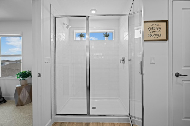 full bath featuring a shower stall and baseboards