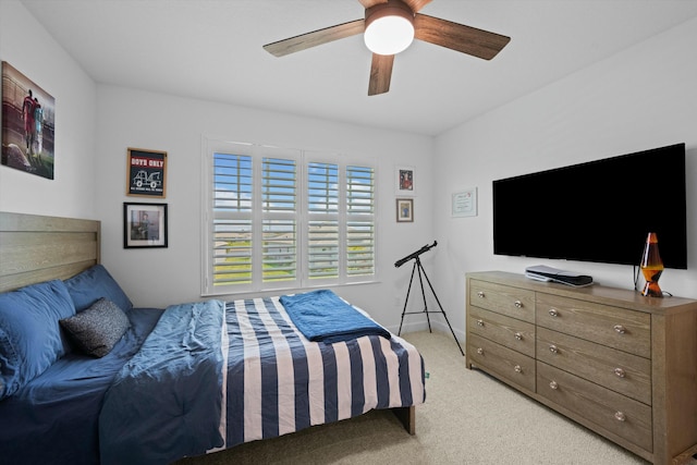 bedroom with light carpet, ceiling fan, and baseboards