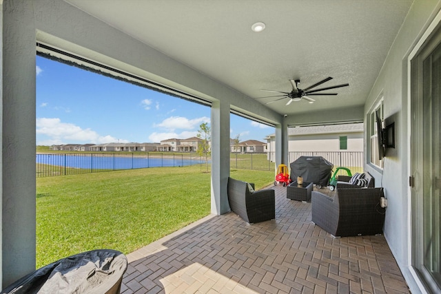 sunroom with a water view and ceiling fan