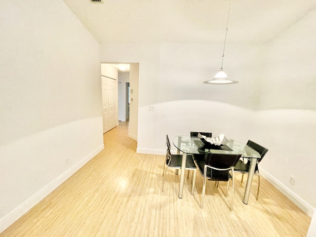 dining room featuring baseboards and light wood finished floors