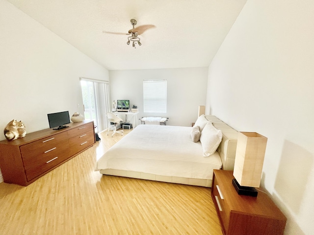 bedroom featuring light wood-type flooring, multiple windows, a ceiling fan, and vaulted ceiling