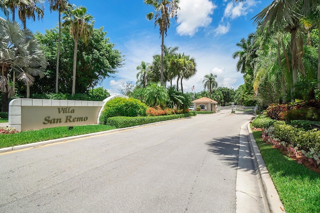 view of road with a gated entry and curbs