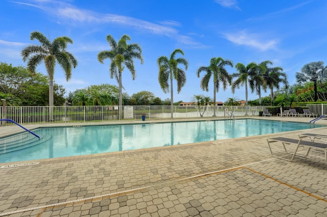 community pool with a patio and fence