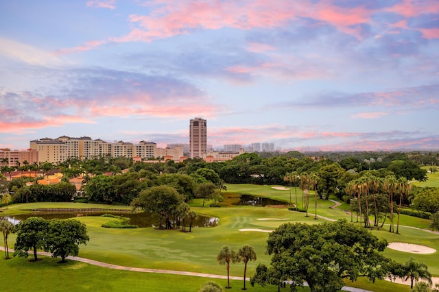 view of community with a view of city, view of golf course, a water view, and a lawn