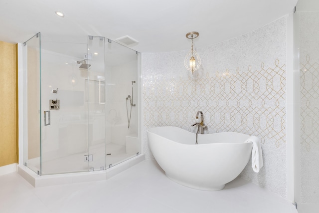 full bathroom featuring visible vents, a soaking tub, a shower stall, and tile walls