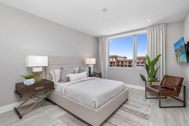 bedroom with recessed lighting, wood finished floors, and baseboards