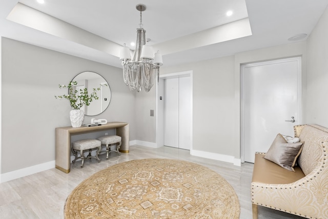 living area with baseboards, elevator, a tray ceiling, a notable chandelier, and recessed lighting