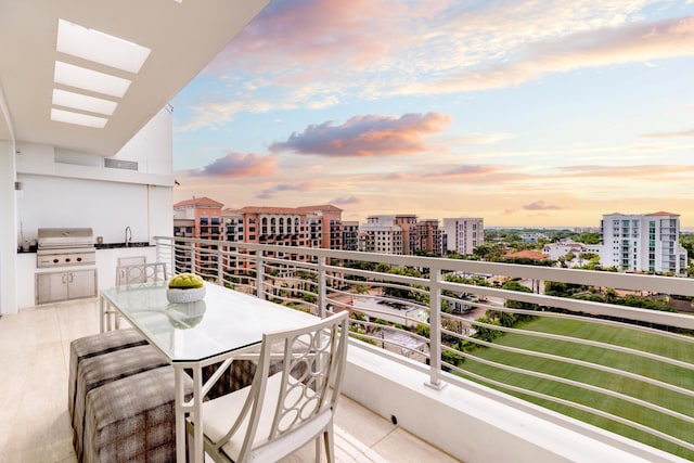 balcony at dusk with a view of city, visible vents, grilling area, and a sink