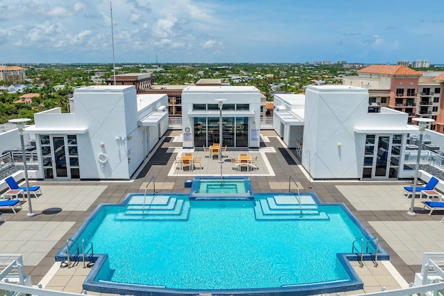 pool with a patio area and a jacuzzi