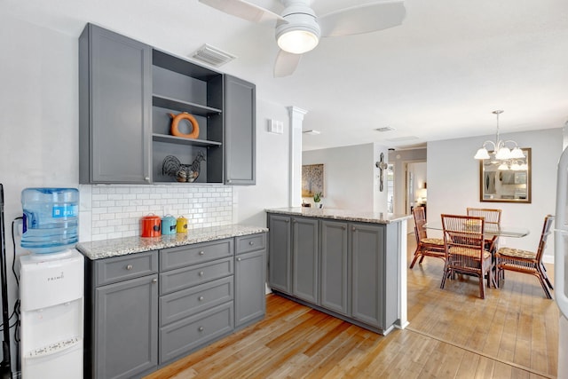 kitchen featuring open shelves, visible vents, gray cabinetry, light wood-style floors, and pendant lighting