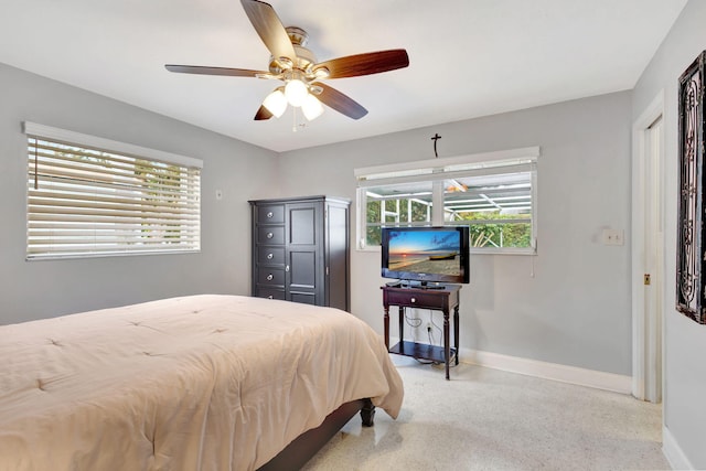 bedroom with light speckled floor, baseboards, and a ceiling fan