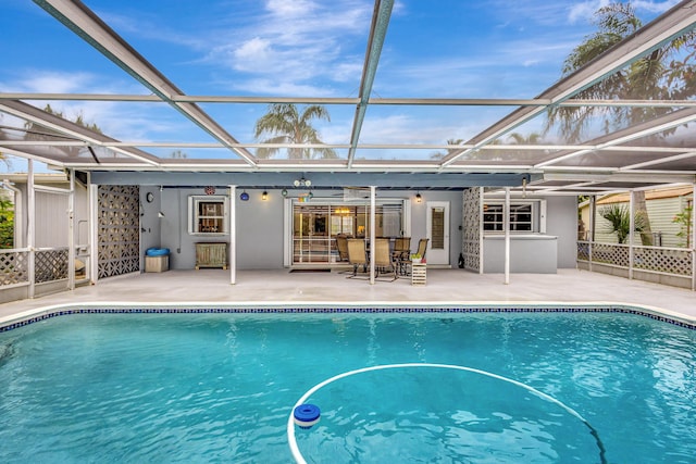 pool featuring glass enclosure and a patio area