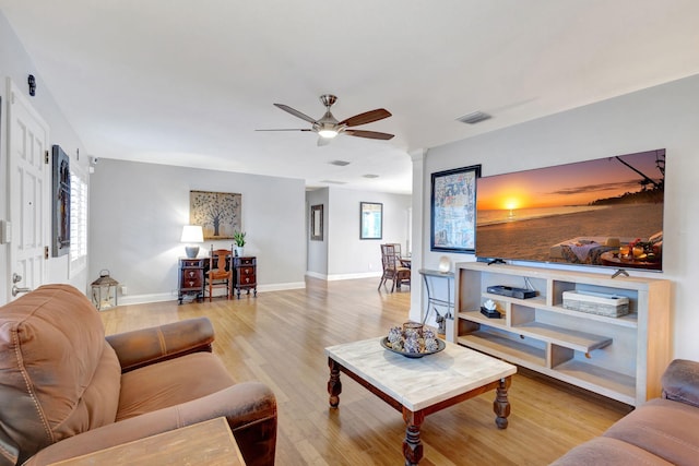 living room featuring visible vents, ceiling fan, light wood-style flooring, and baseboards