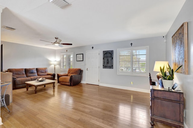 living room featuring light wood-style floors, a healthy amount of sunlight, and visible vents