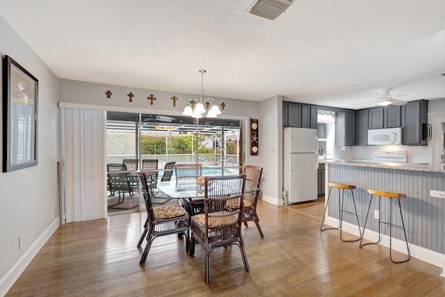 dining room featuring visible vents, light wood-style flooring, and baseboards