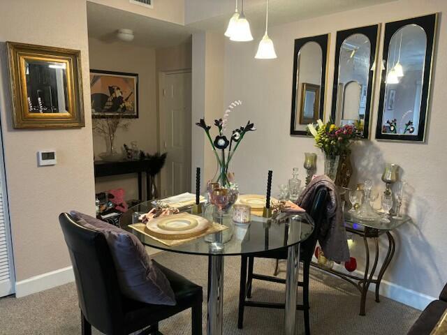 dining area featuring carpet floors, visible vents, and baseboards