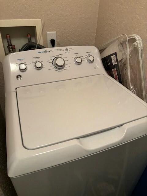 washroom with washer / clothes dryer and a textured wall