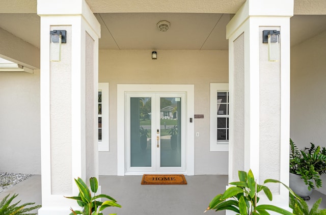 entrance to property featuring stucco siding and french doors