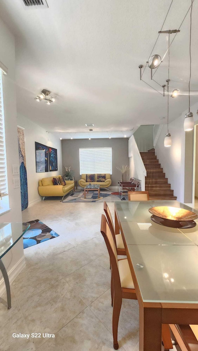 dining area with stairway, visible vents, and baseboards