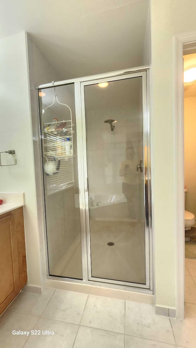 bathroom with a stall shower, tile patterned flooring, and vanity